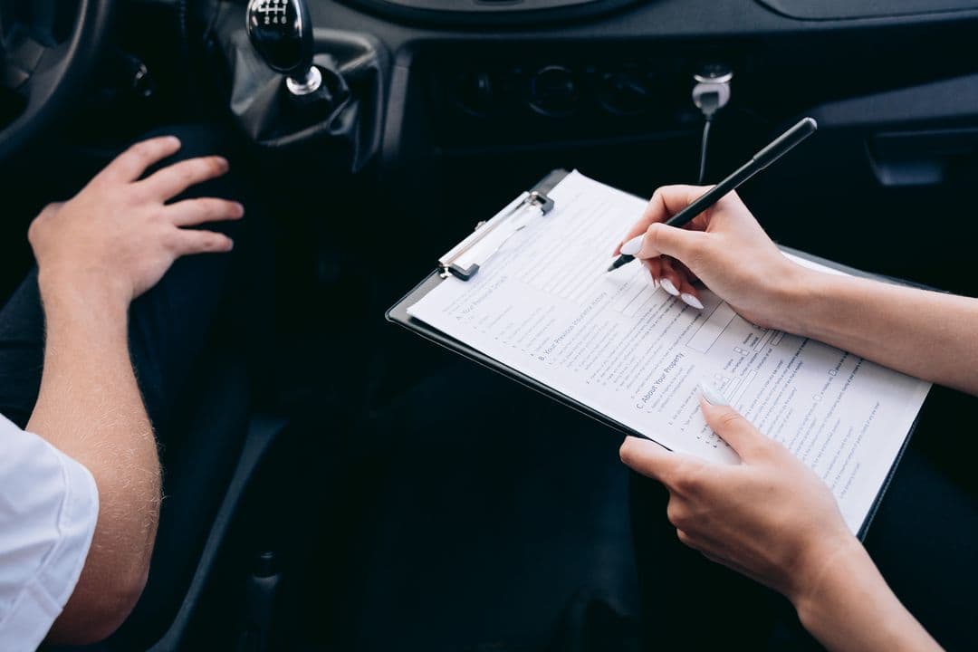 Reviewing car maintenance records on a clipboard, the paper trail that raises a car's resale value