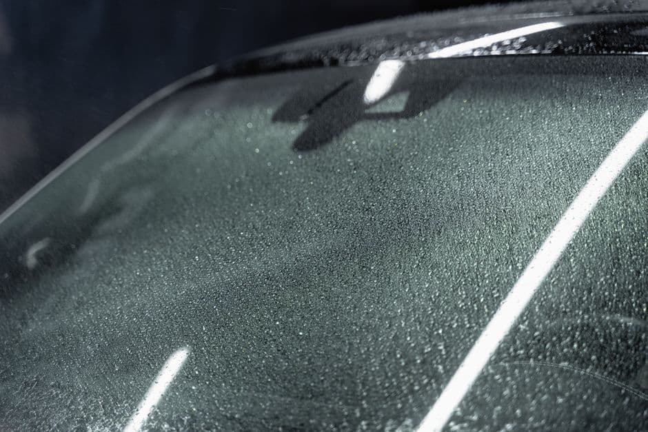 Car windshield with raindrops, showing the glass surface where chips and cracks typically start
