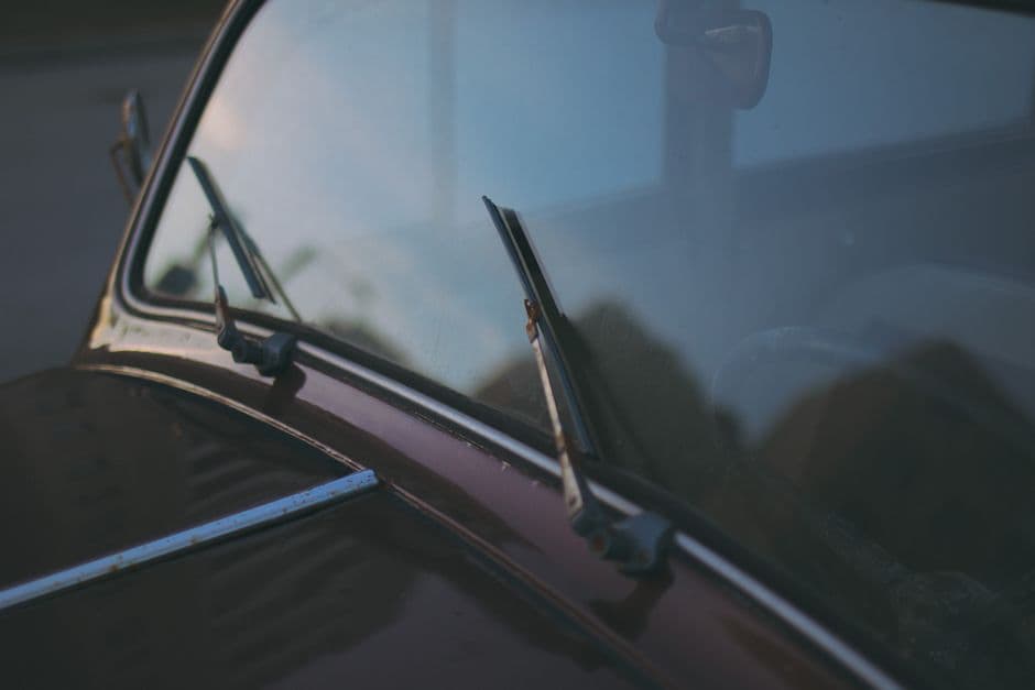 Close-up of a windshield wiper blade resting against a car windshield